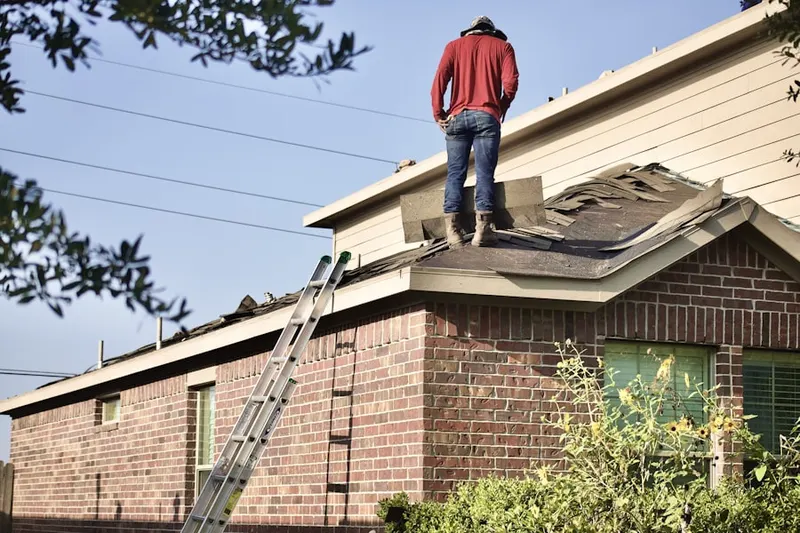 Professional roofer working on a residential roof in Baldwin City